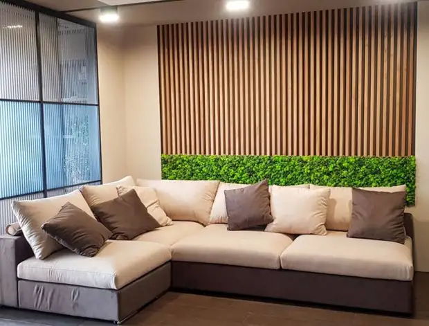 небольшая гостиная с диваном, рейки из дерева на стене