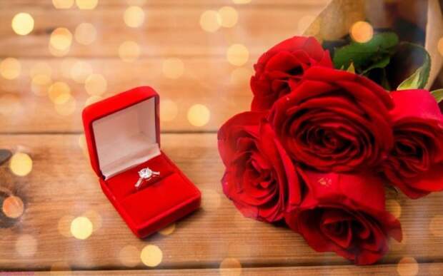 кольцо в красной коробочке и букет красных роз