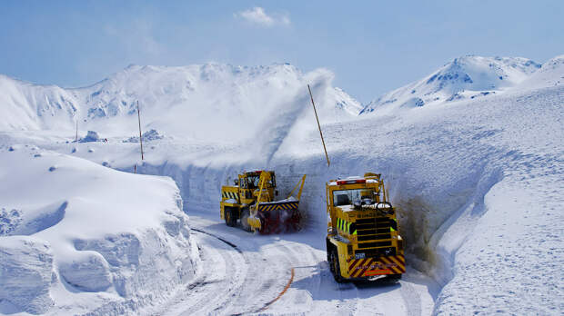 TATEYAMA, JAPAN - MAY 10, 2014: Unidentified tourists walk along snow corridor on Tateyama Kurobe Alpine Route, Japanese Alp in Tateyama, Japan